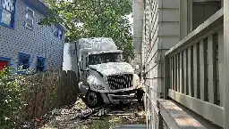 Driverless semi-truck rolls through Lawrence residential area, comes to rest between two homes